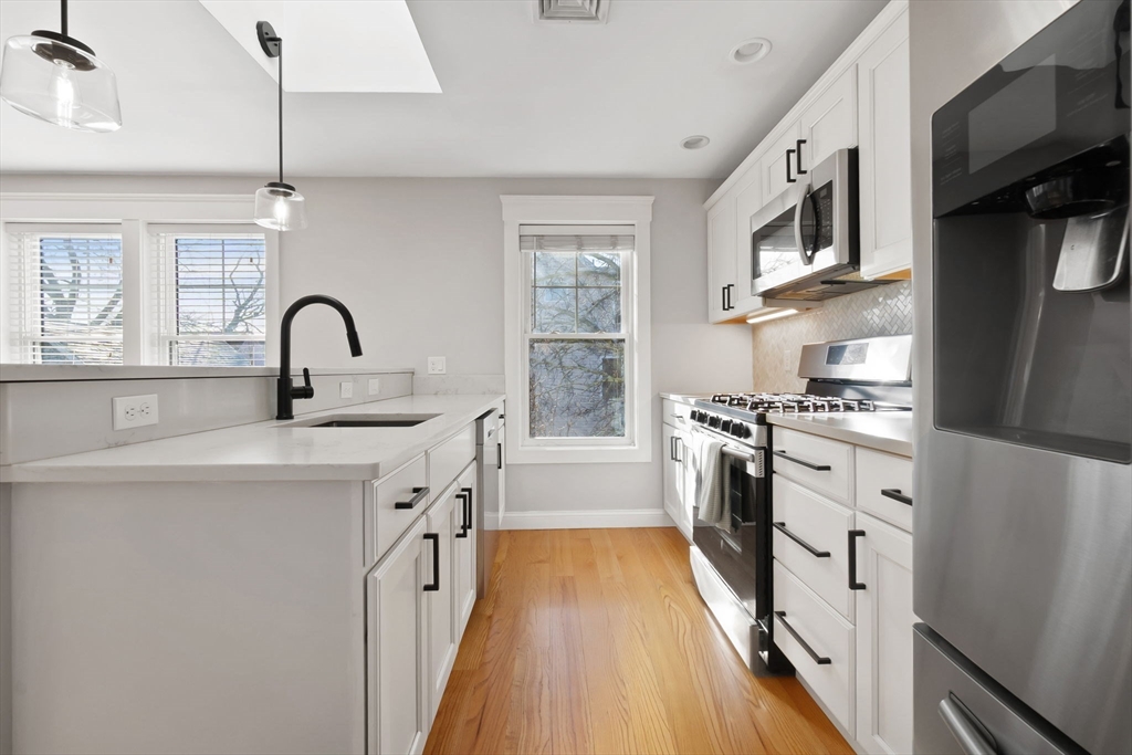 85 Bridge Street, Unit 4 Salem, MA 01970 - Photo 9 of 31 a kitchen with stainless steel appliances a sink a stove top oven a counter space and cabinets