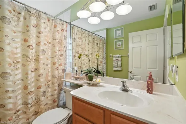 a bathroom with a sink vanity mirror and toilet