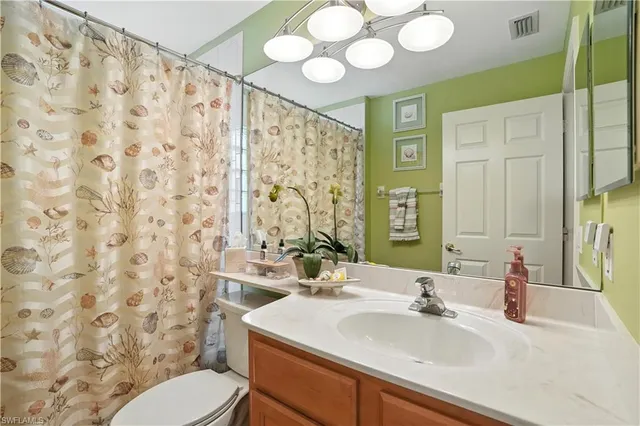 a bathroom with a sink vanity mirror and toilet