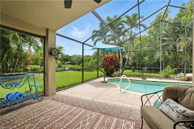 a view of a chair and tables in the patio with a backyard