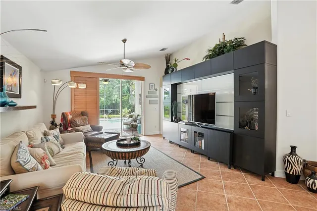 a living room with furniture a flat screen tv and a large window