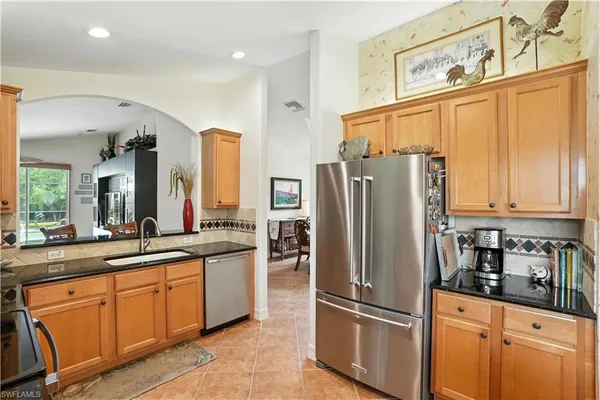 a kitchen with stainless steel appliances granite countertop a refrigerator and a sink