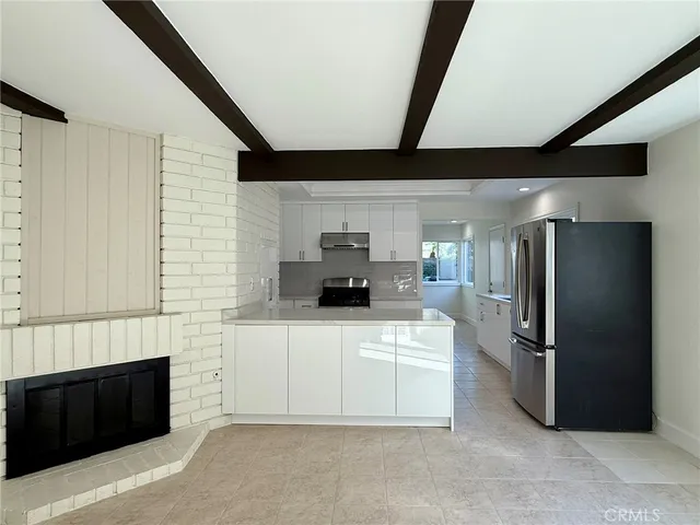 a kitchen with stainless steel appliances kitchen island granite countertop a refrigerator and a stove top oven