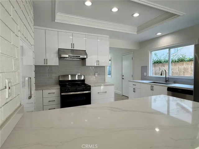 a kitchen with stainless steel appliances a stove sink and cabinets