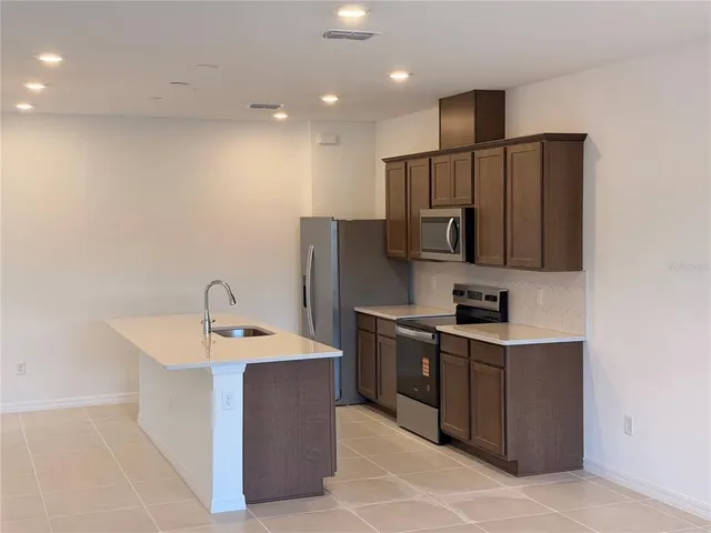 a kitchen with a sink stainless steel appliances and counter space