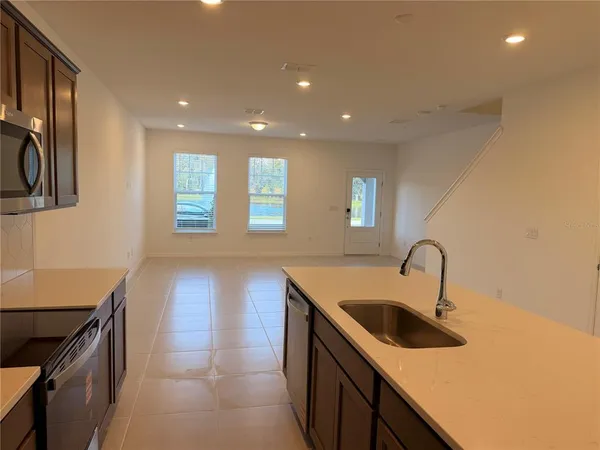 a kitchen with a sink and a stove top oven with wooden floor