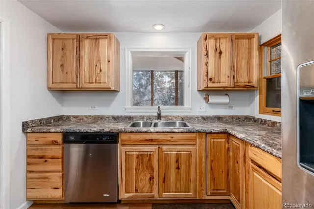 a kitchen with granite countertop a sink and a stove