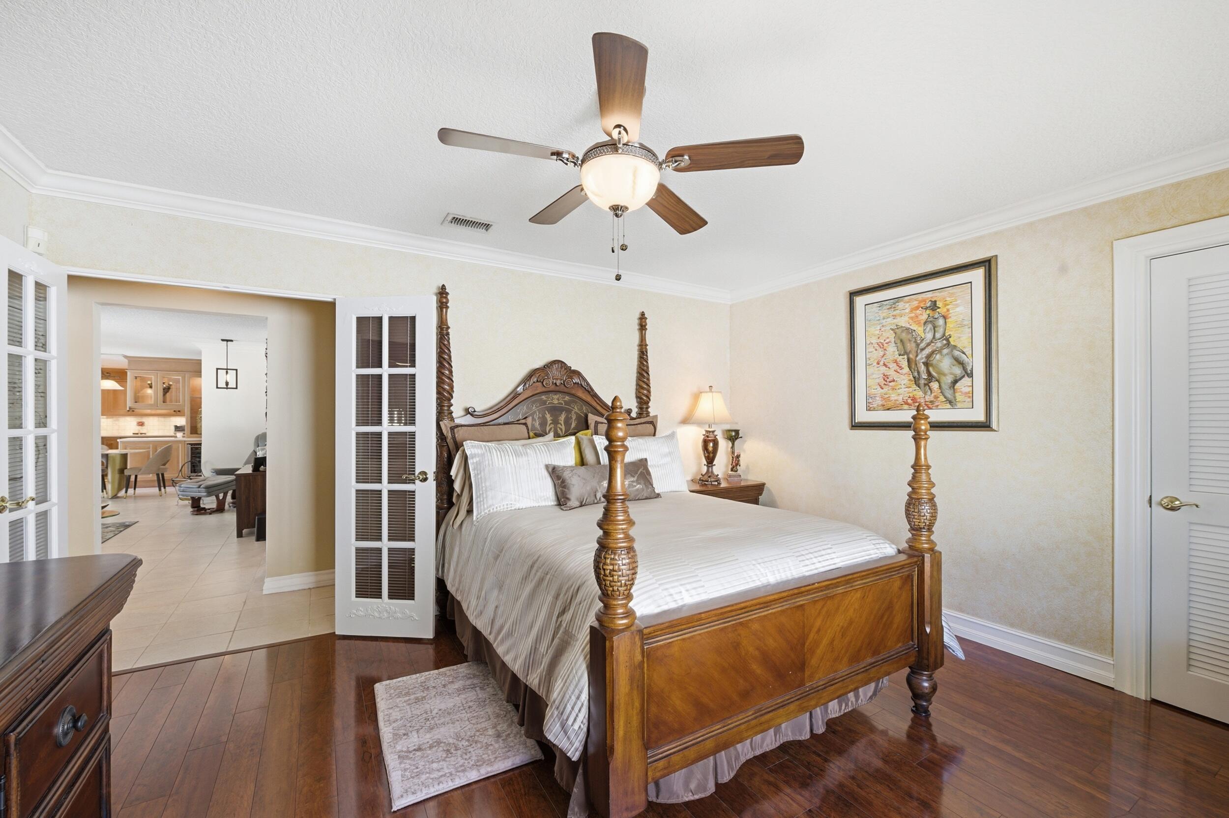 4780 Brandywine Drive Boca Raton, FL 33487 - Photo 21 of 43 a bedroom with a bed and wooden floor