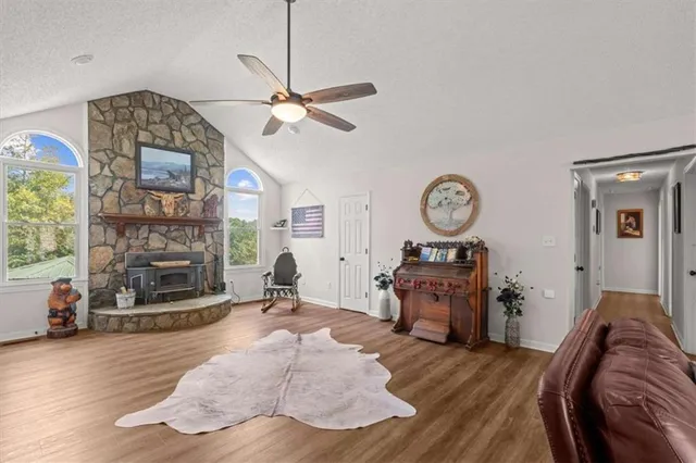 a kitchen with stainless steel appliances granite countertop a stove top oven a sink dishwasher and white cabinets with wooden floor