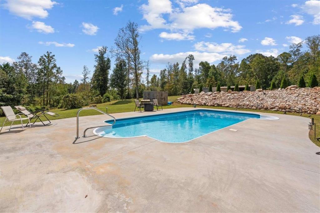 6058 Mt Zion Road Waco, GA 30182 - Photo 52 of 72 a view of a swimming pool with a yard and sitting area