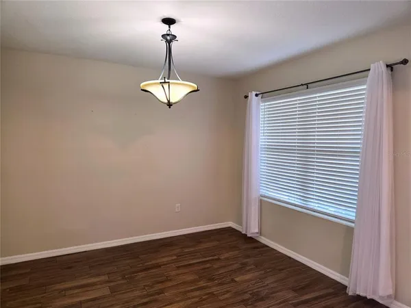 a view of empty room with wooden floor and window