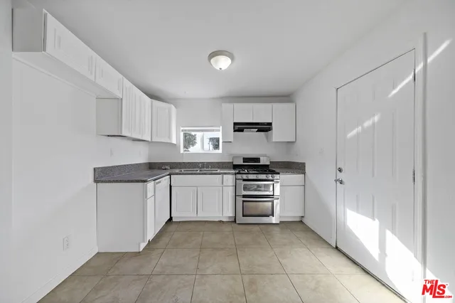 a kitchen with granite countertop a refrigerator and a stove