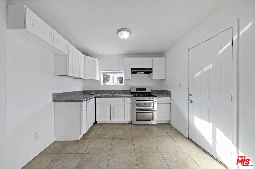 66124 Acoma Avenue, Unit C Desert Hot Springs, CA 92240 - Photo 2 of 18 a kitchen with granite countertop a refrigerator and a stove
