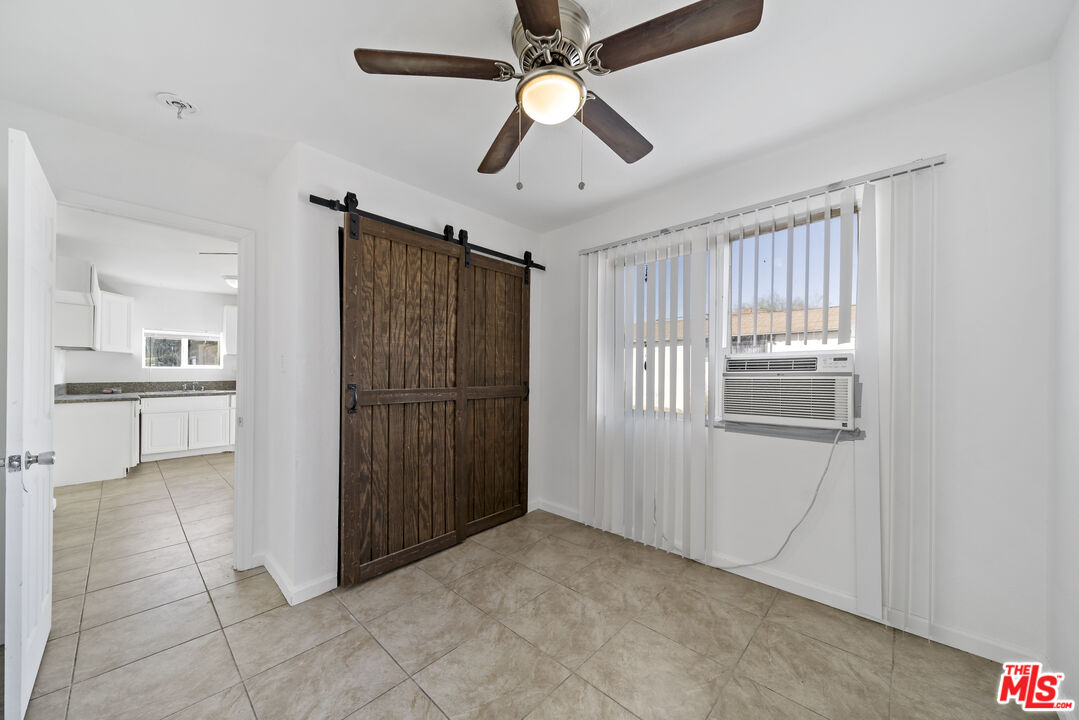 66124 Acoma Avenue, Unit C Desert Hot Springs, CA 92240 - Photo 4 of 18 a view of a kitchen with an empty space and a ceiling fan