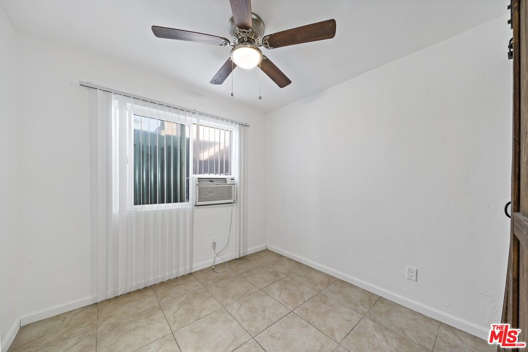 66124 Acoma Avenue, Unit C Desert Hot Springs, CA 92240 - Photo 8 of 18 an empty room with windows and fan