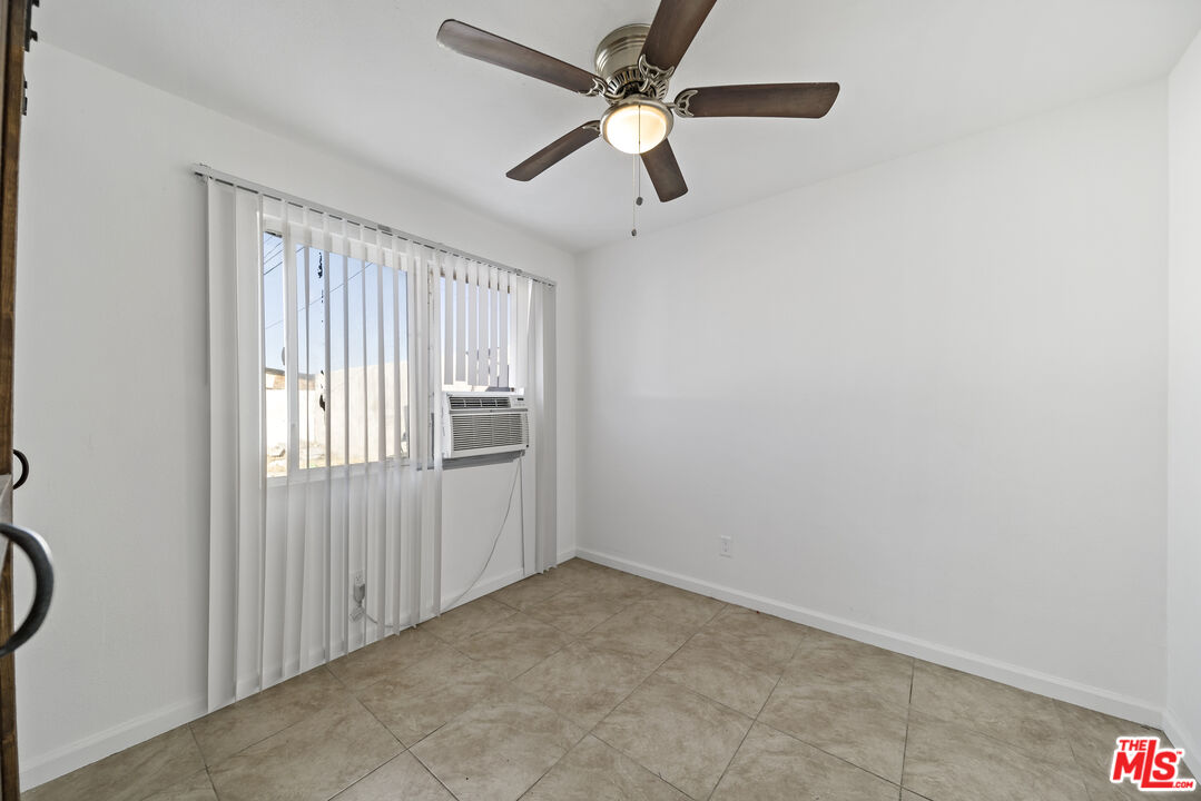 66124 Acoma Avenue, Unit C Desert Hot Springs, CA 92240 - Photo 9 of 18 an empty room with windows and fan