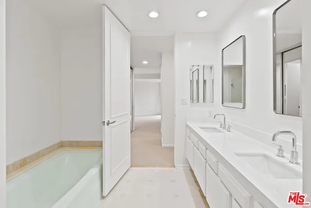 a spacious bathroom with a tub sink and mirror