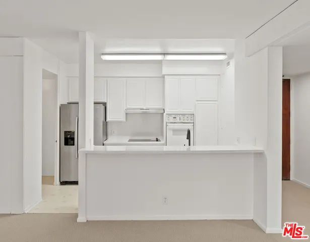 a kitchen with stainless steel appliances a refrigerator and cabinets