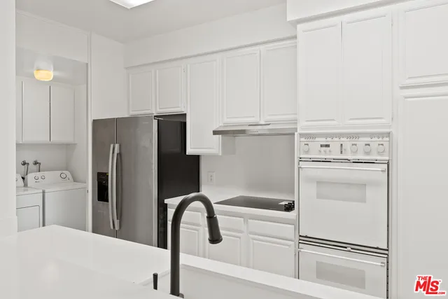 a kitchen with white cabinets and white appliances