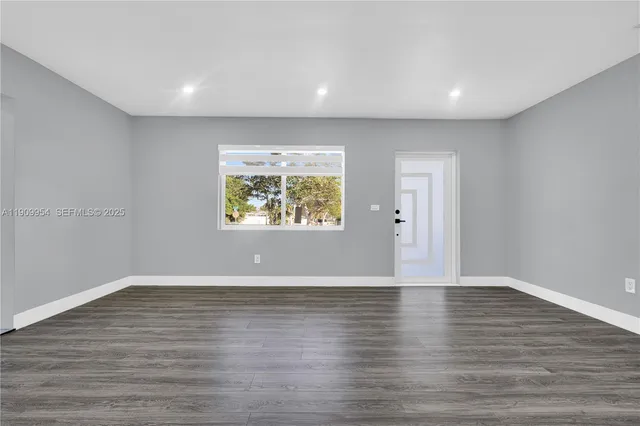 a view of an empty room with wooden floor