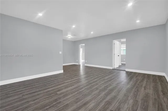 an empty room with wooden floor and a window