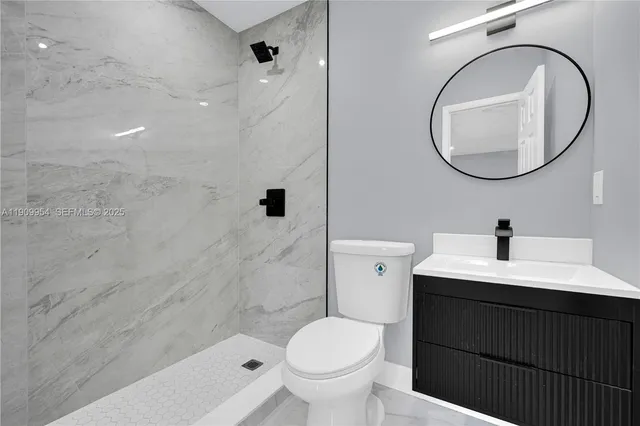 a bathroom with a sink toilet and a mirror