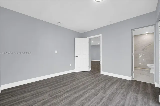 a view of a kitchen with a sink refrigerator and wooden floor