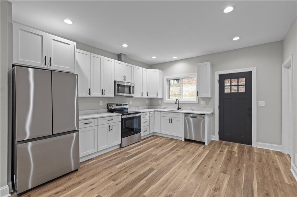 817 Eldora Place Pittsburgh, PA 15210 - Photo 7 of 29 a kitchen with white cabinets and stainless steel appliances