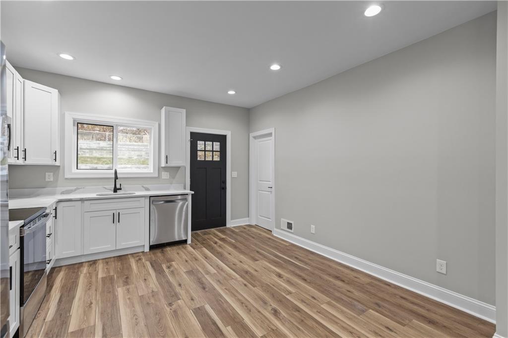 817 Eldora Place Pittsburgh, PA 15210 - Photo 10 of 29 a large white kitchen with granite countertop a sink white cabinets and stainless steel appliances