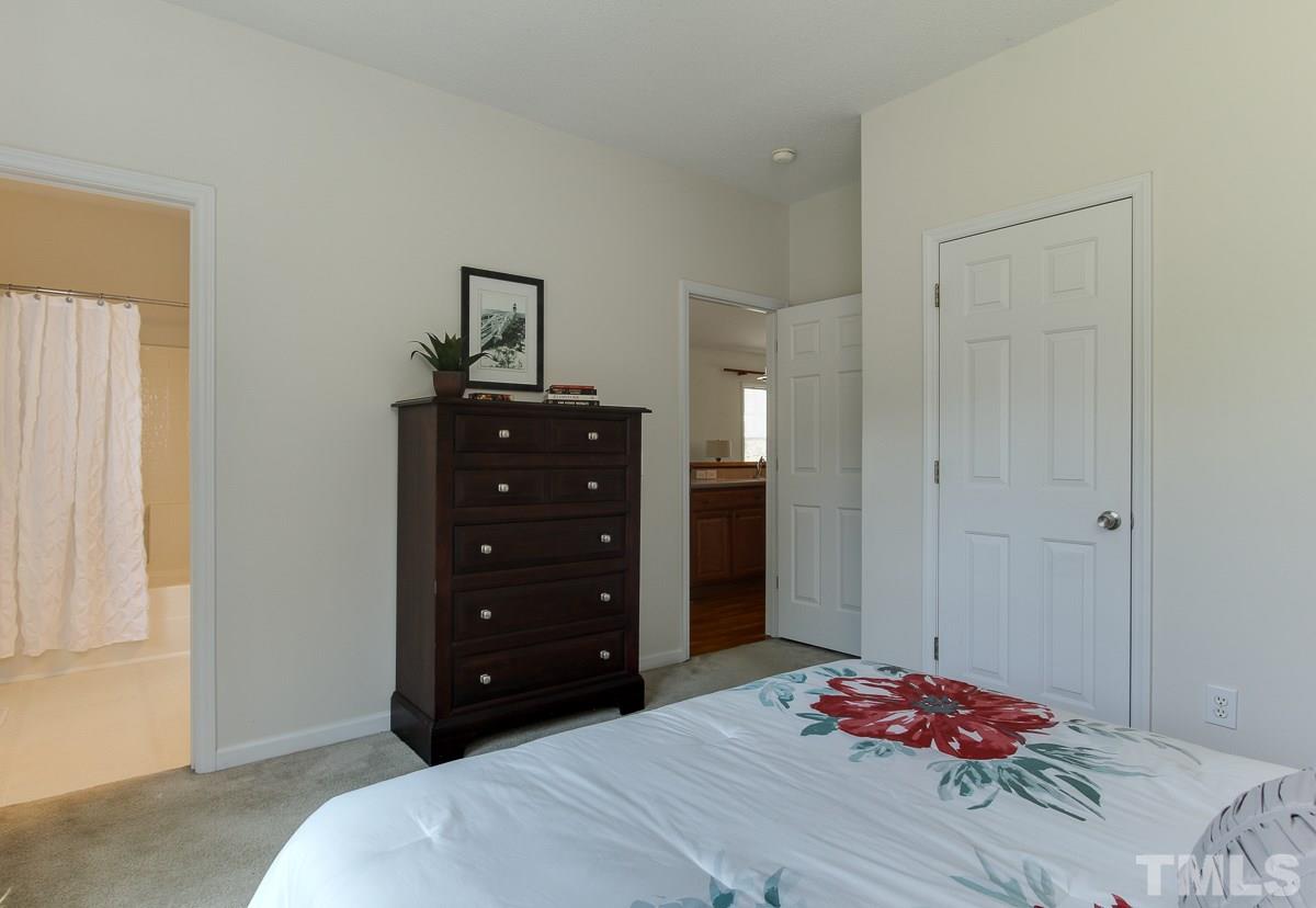 558 East Martin Street Raleigh, NC 27601 - Photo 14 of 24 a bedroom with a bed a chandelier and a window