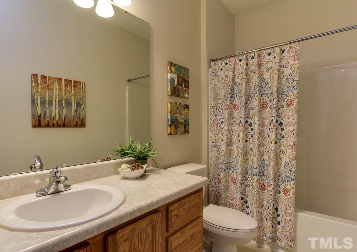 558 East Martin Street Raleigh, NC 27601 - Photo 18 of 24 a bathroom with a granite countertop sink a toilet and a mirror