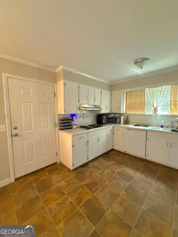 a kitchen with a cabinets and white appliances