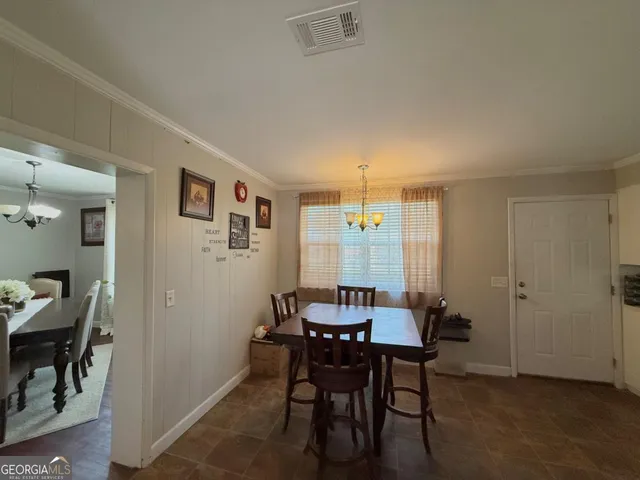a view of a dining room with furniture and chandelier