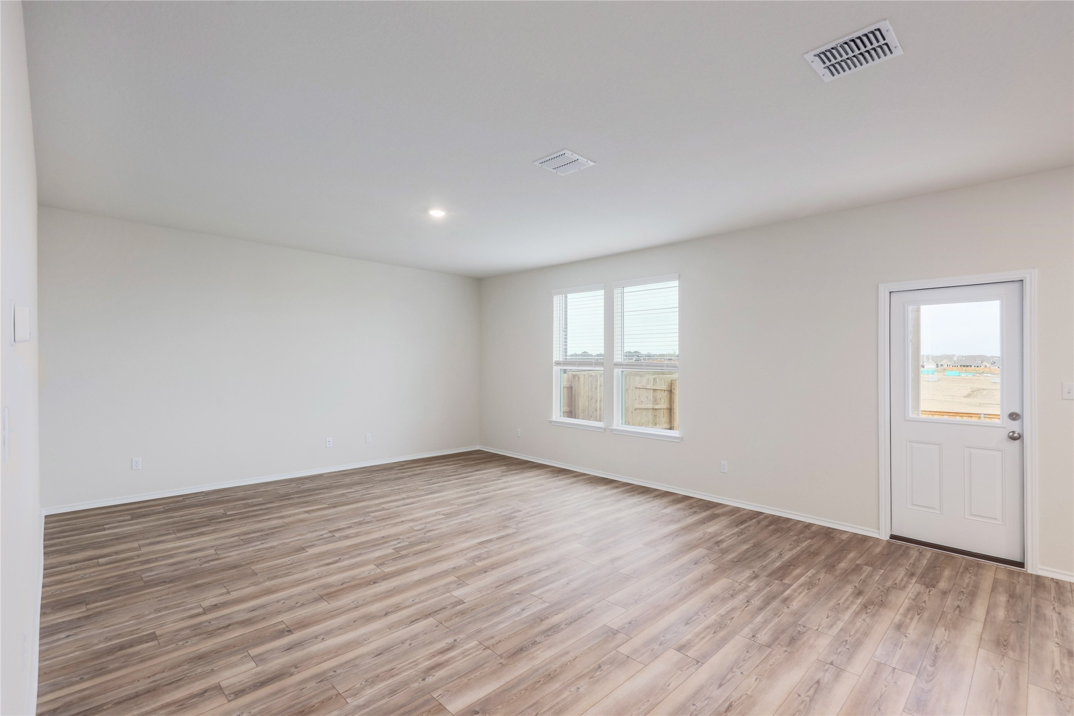 212 Sugar Cane Road Buda, TX 78610 - Photo 7 of 40 an empty room with wooden floor and windows