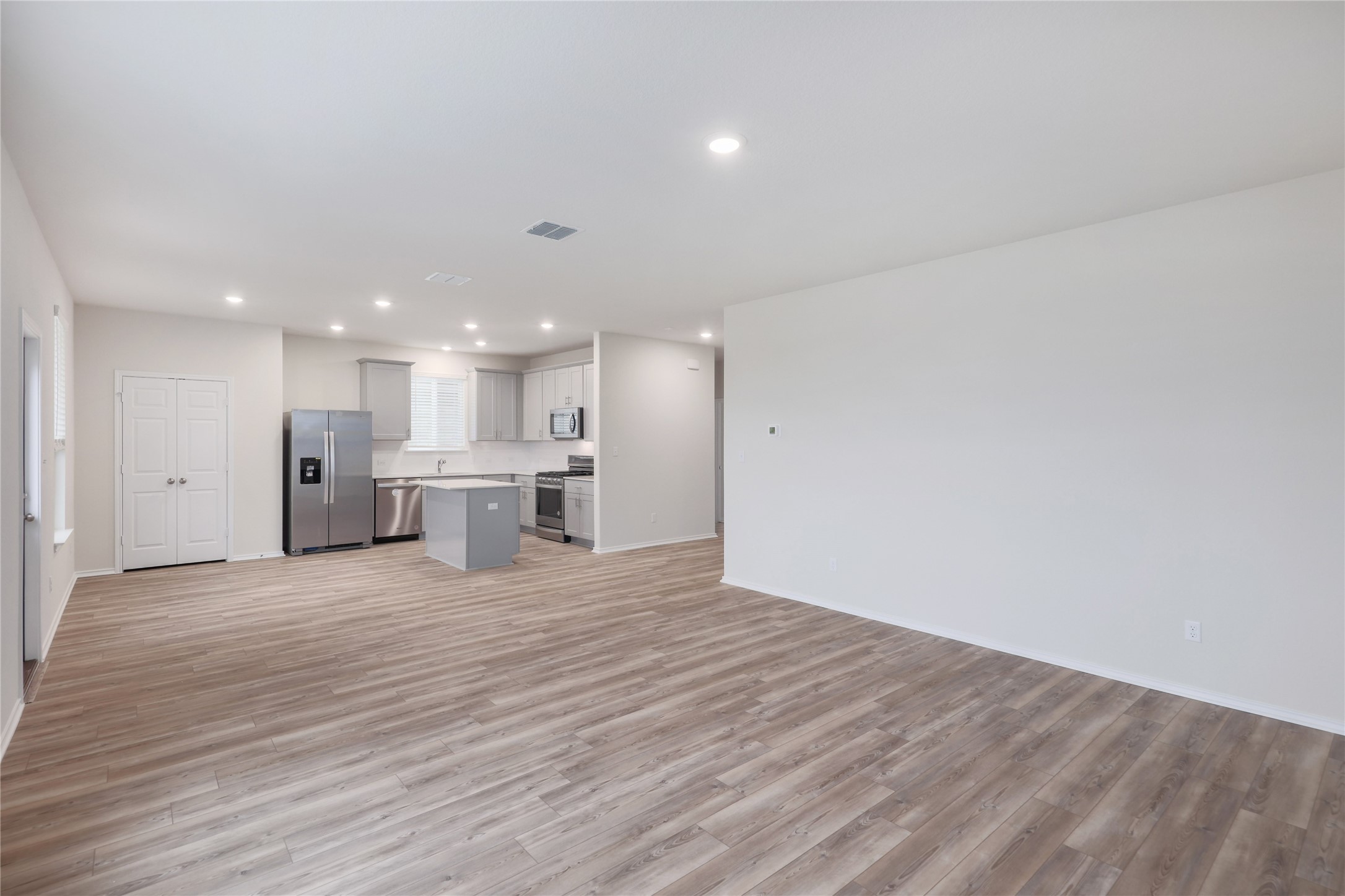 212 Sugar Cane Road Buda, TX 78610 - Photo 8 of 40 a view of kitchen with kitchen island wooden floor center island and stainless steel appliances