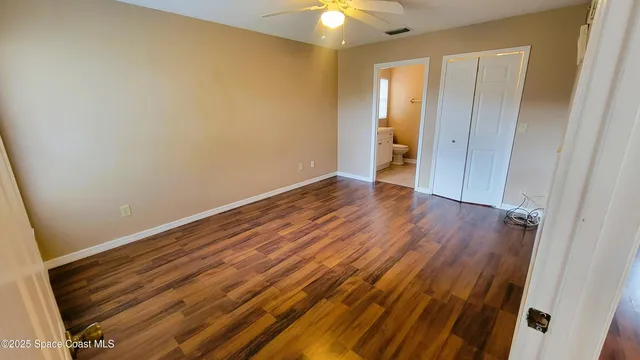a view of an empty room with closet and a window