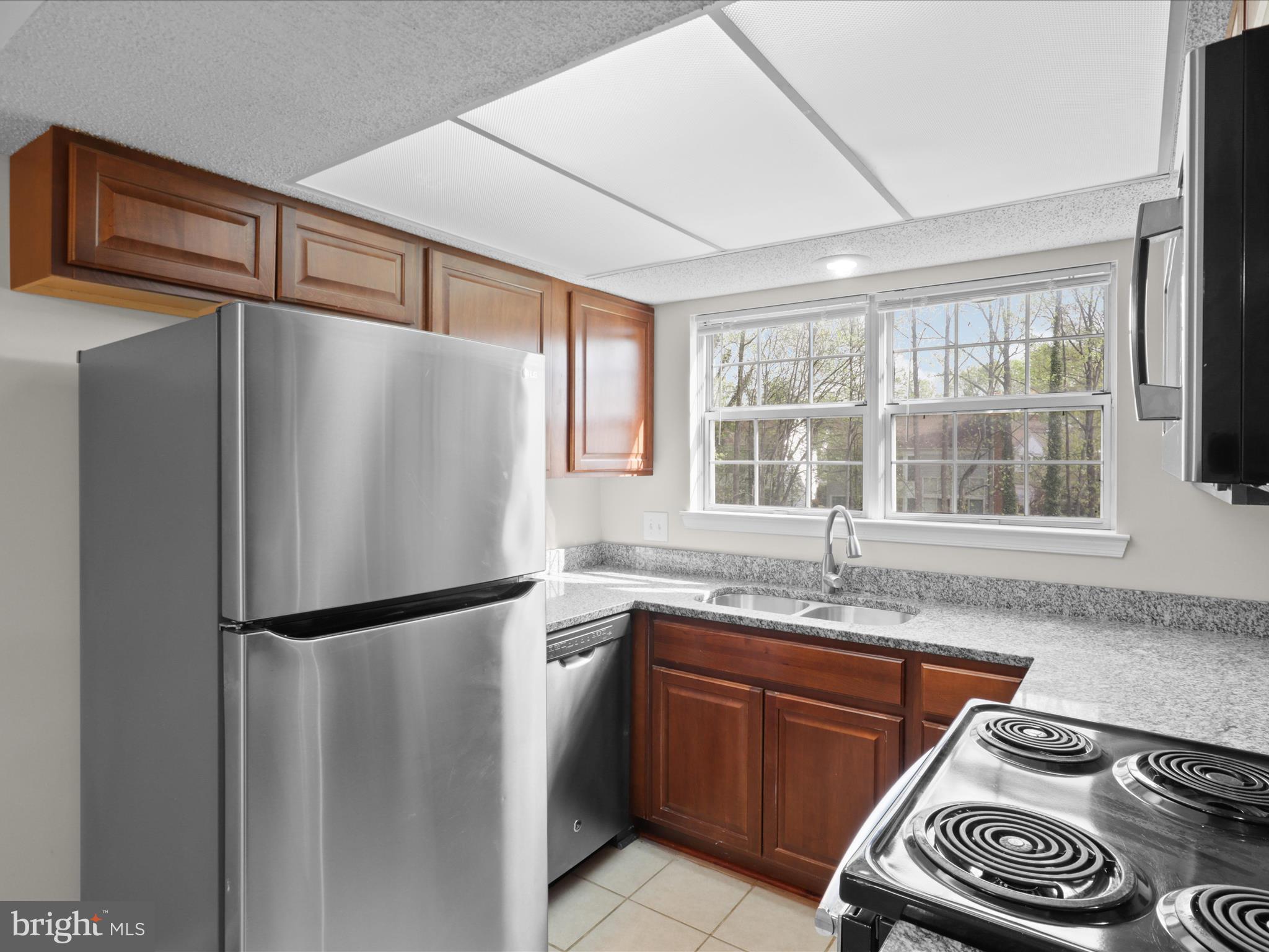 12008 Golf Ridge Court, Unit 356 Fairfax, VA 22033 - Photo 8 of 33 a kitchen with stainless steel appliances granite countertop a refrigerator and a sink