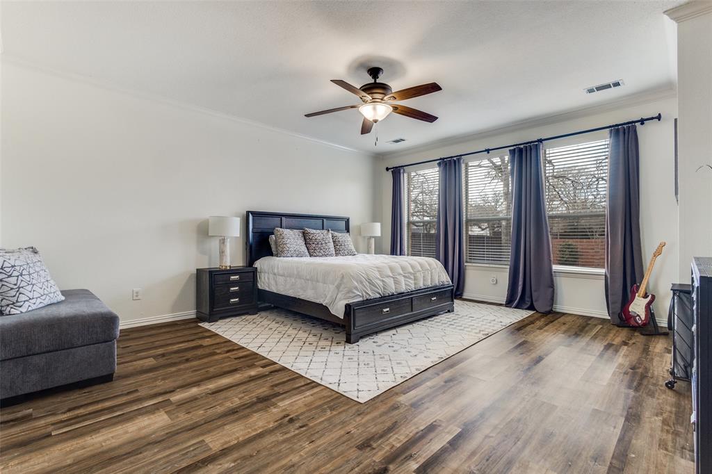 1524 Rustic Timbers Lane Flower Mound, TX 75028 - Photo 11 of 28 a bedroom with a large bed and a chandelier
