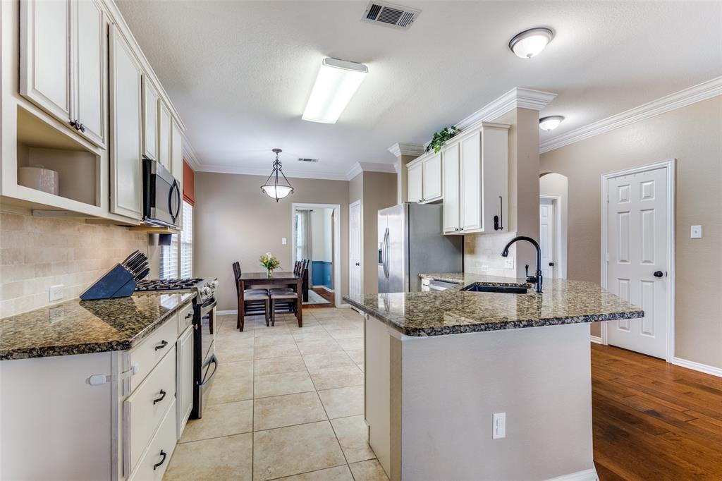 1524 Rustic Timbers Lane Flower Mound, TX 75028 - Photo 6 of 28 a kitchen with granite countertop sink cabinets and stainless steel appliances