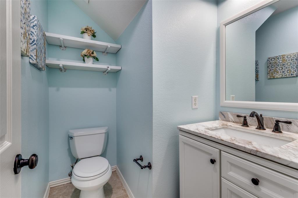 1524 Rustic Timbers Lane Flower Mound, TX 75028 - Photo 10 of 28 a bathroom with a granite countertop toilet sink and mirror