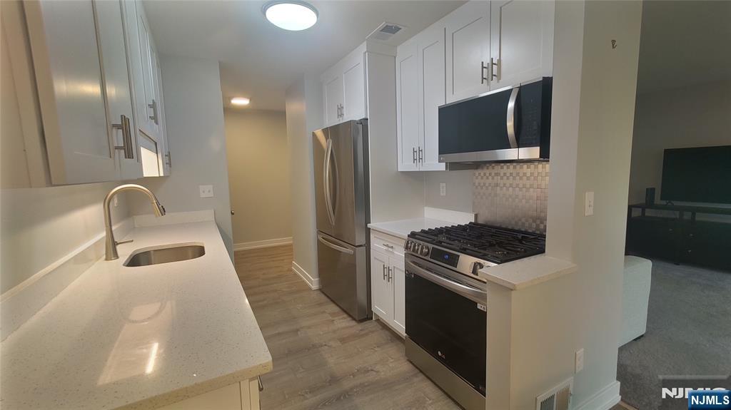 1103 Hilltop Road Mahwah, NJ 07430 - Photo 4 of 17 a kitchen with stainless steel appliances granite countertop a sink stove and refrigerator