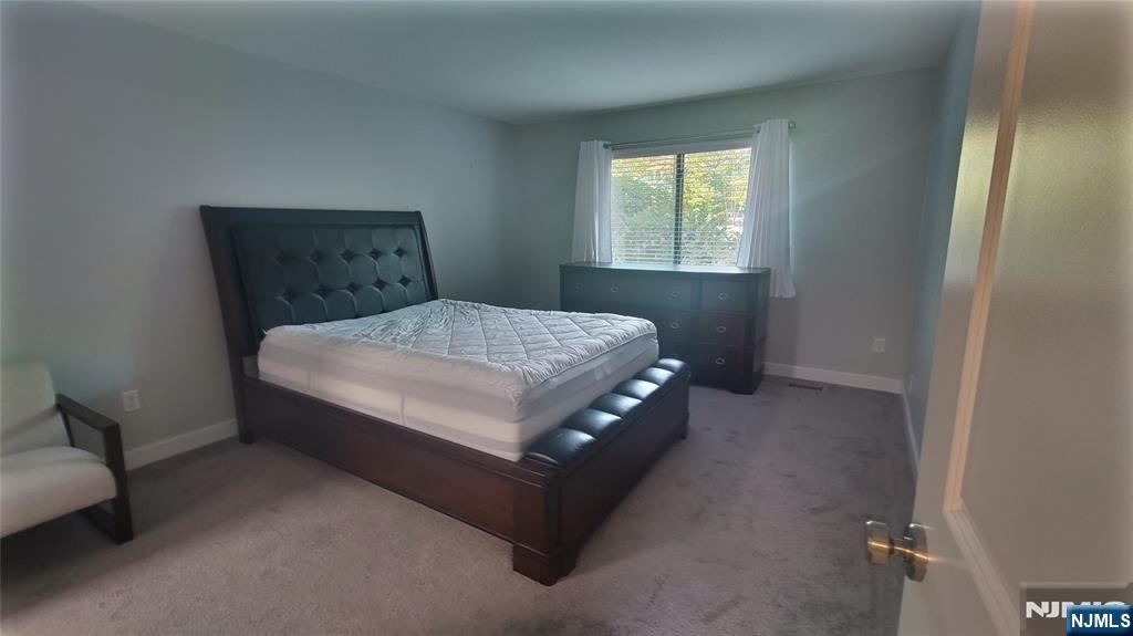 1103 Hilltop Road Mahwah, NJ 07430 - Photo 10 of 17 a bed sitting in a bedroom next to a window