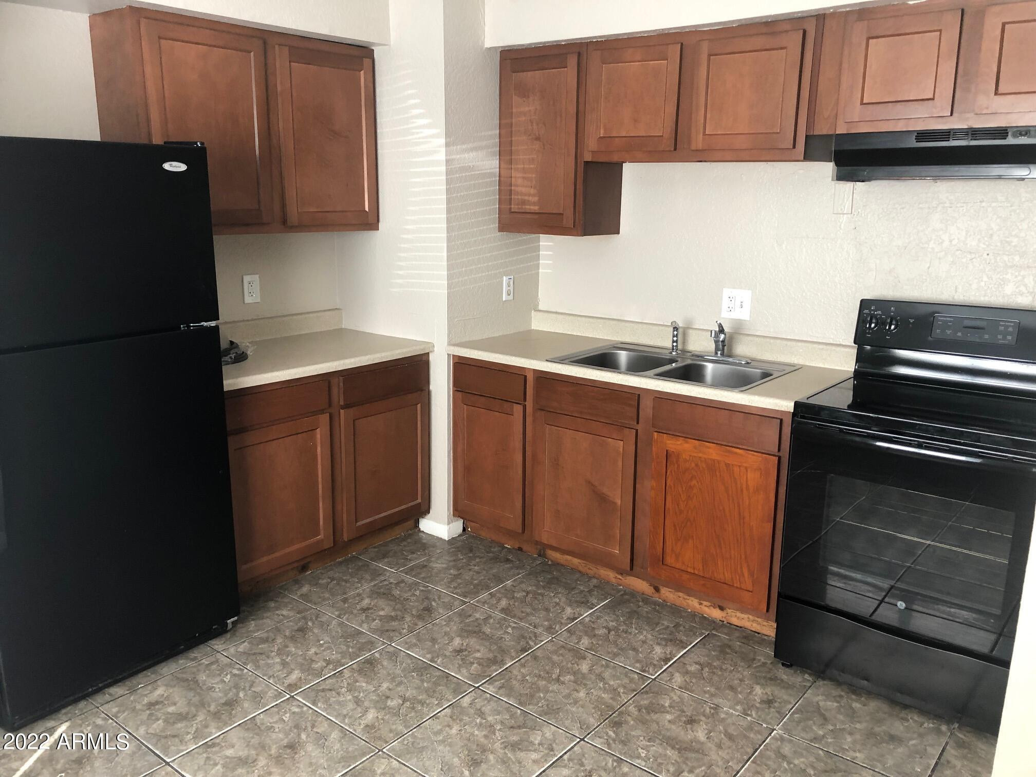 a kitchen with granite countertop a refrigerator stove and sink