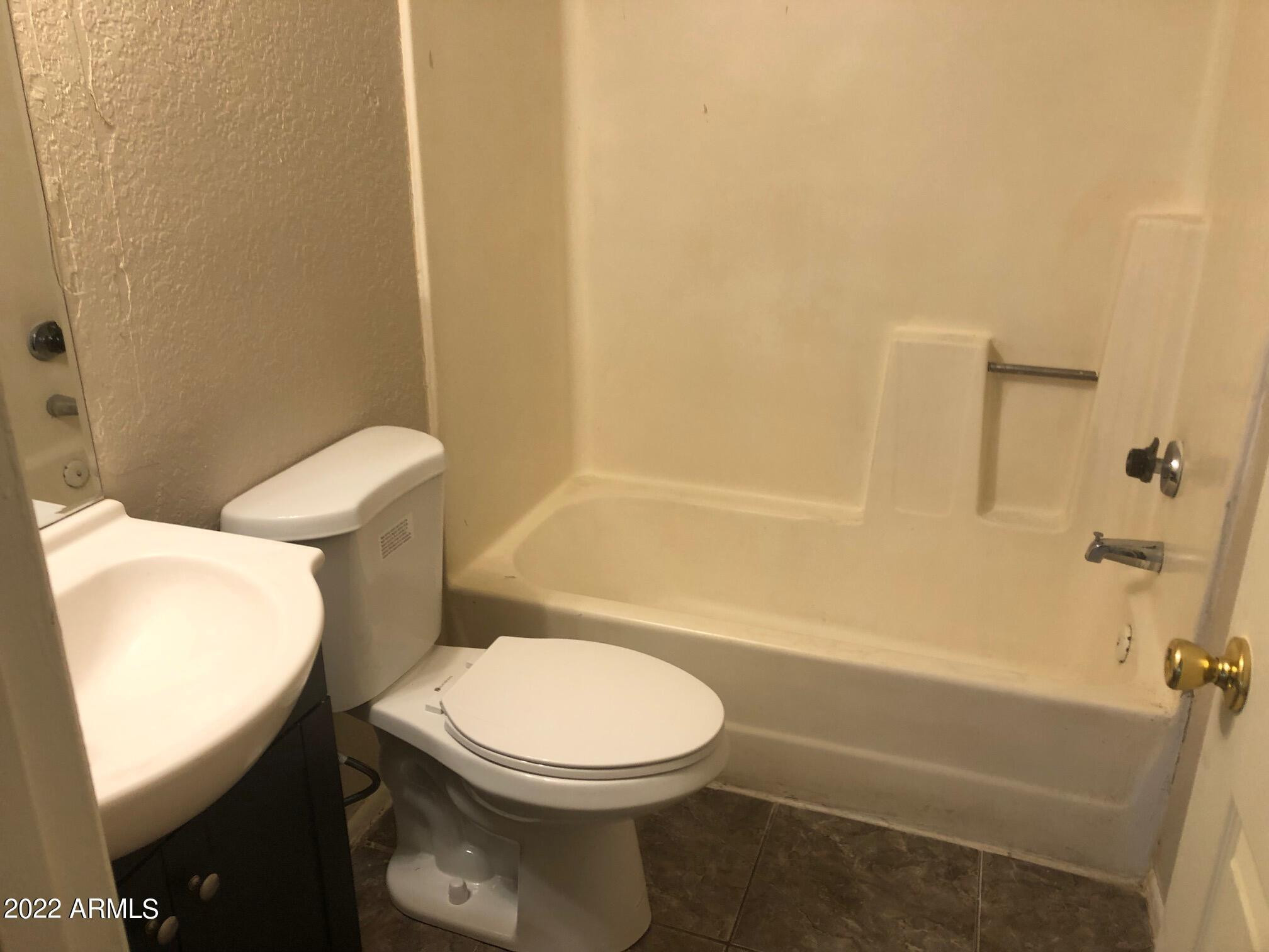 4211 South 3rd Street, Unit 101 Phoenix, AZ 85040 - Photo 5 of 9 a white toilet and tub sitting next to a bathroom sink