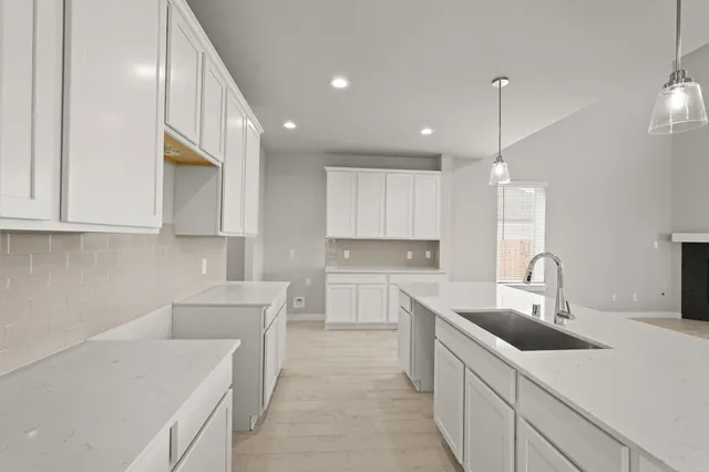 a kitchen with a sink a counter top space stainless steel appliances and cabinets