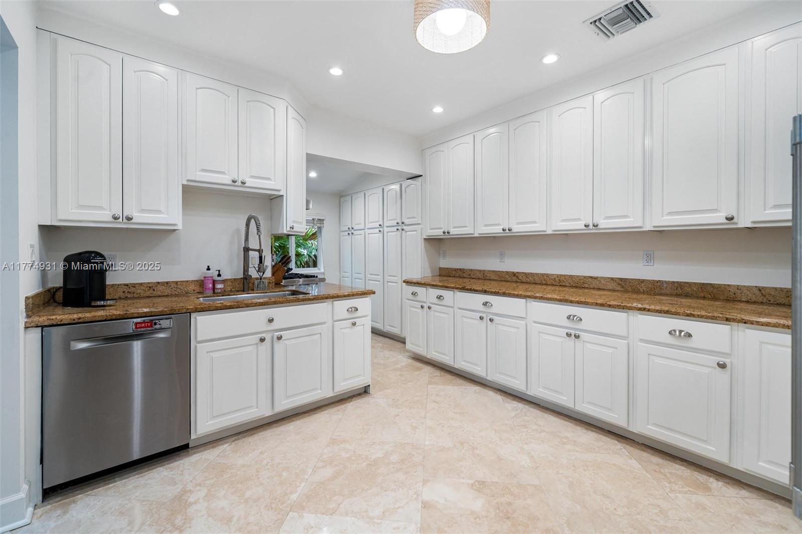 2210 Overbrook Street Miami, FL 33133 - Photo 10 of 26 a kitchen with granite countertop white cabinets stainless steel appliances and a sink