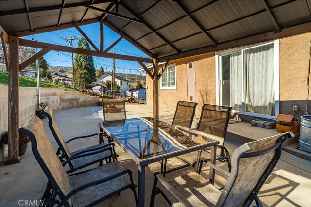 a view of a patio with a table and chairs under an umbrella