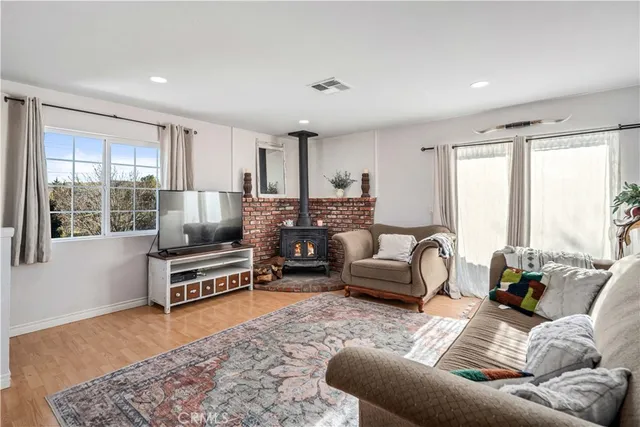 a living room with furniture a flat screen tv and windows