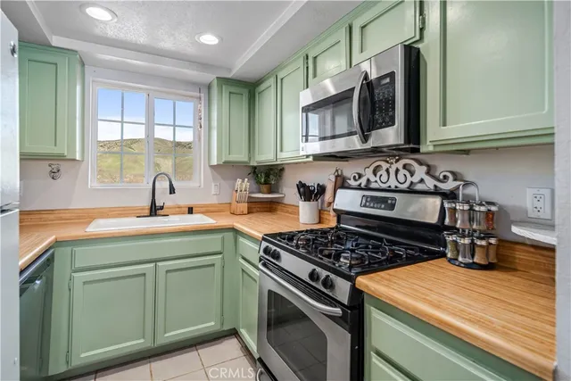 a kitchen with stainless steel appliances granite countertop a stove a sink and a microwave