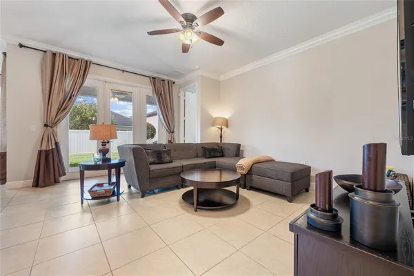 a living room with furniture a flat screen tv and a large window